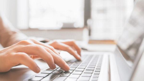 closeup of hands typing on laptop